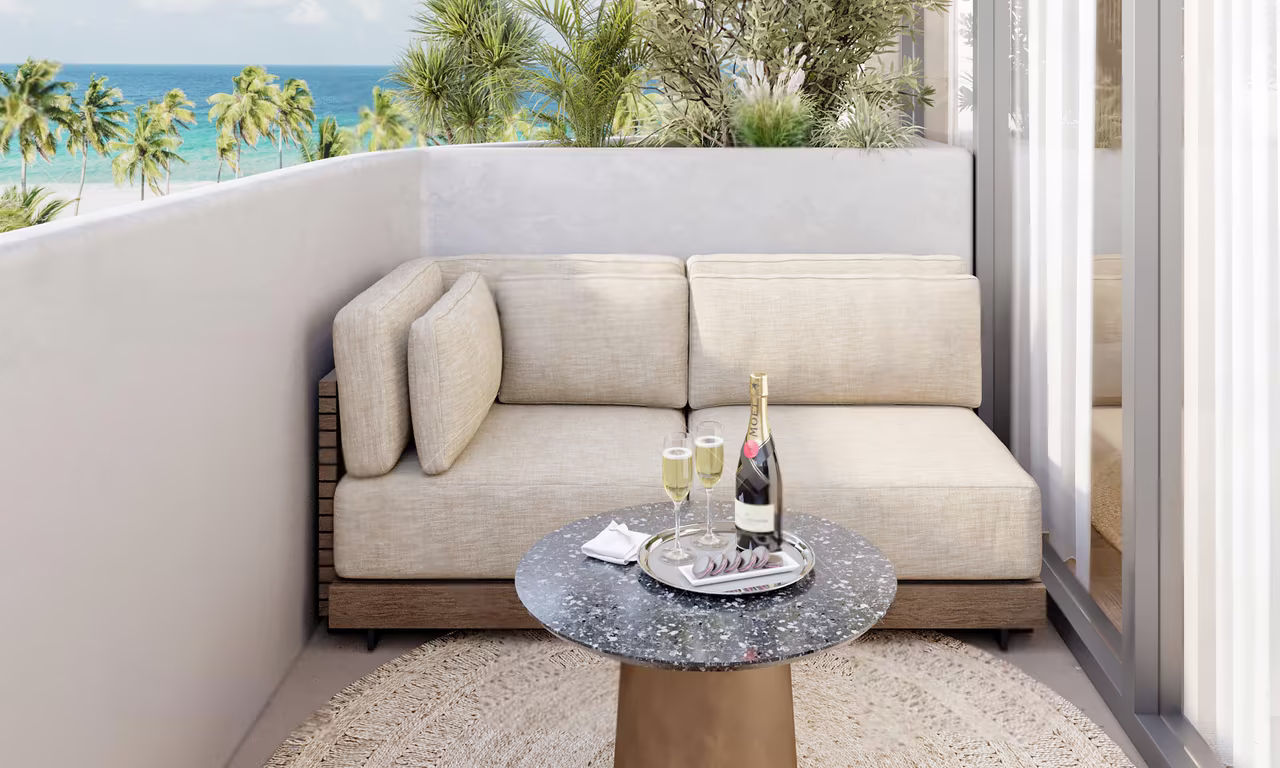 Studio apartment at Azure Paje: furnished balcony with a sofa and a view of the sea and palms