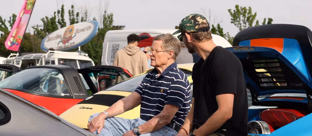 Two men talking beside a classic air-cooled Porsche at Idaho Air & Coffee.