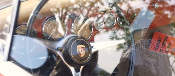 Close-up of classic Porsche steering wheel and dashboard interior details