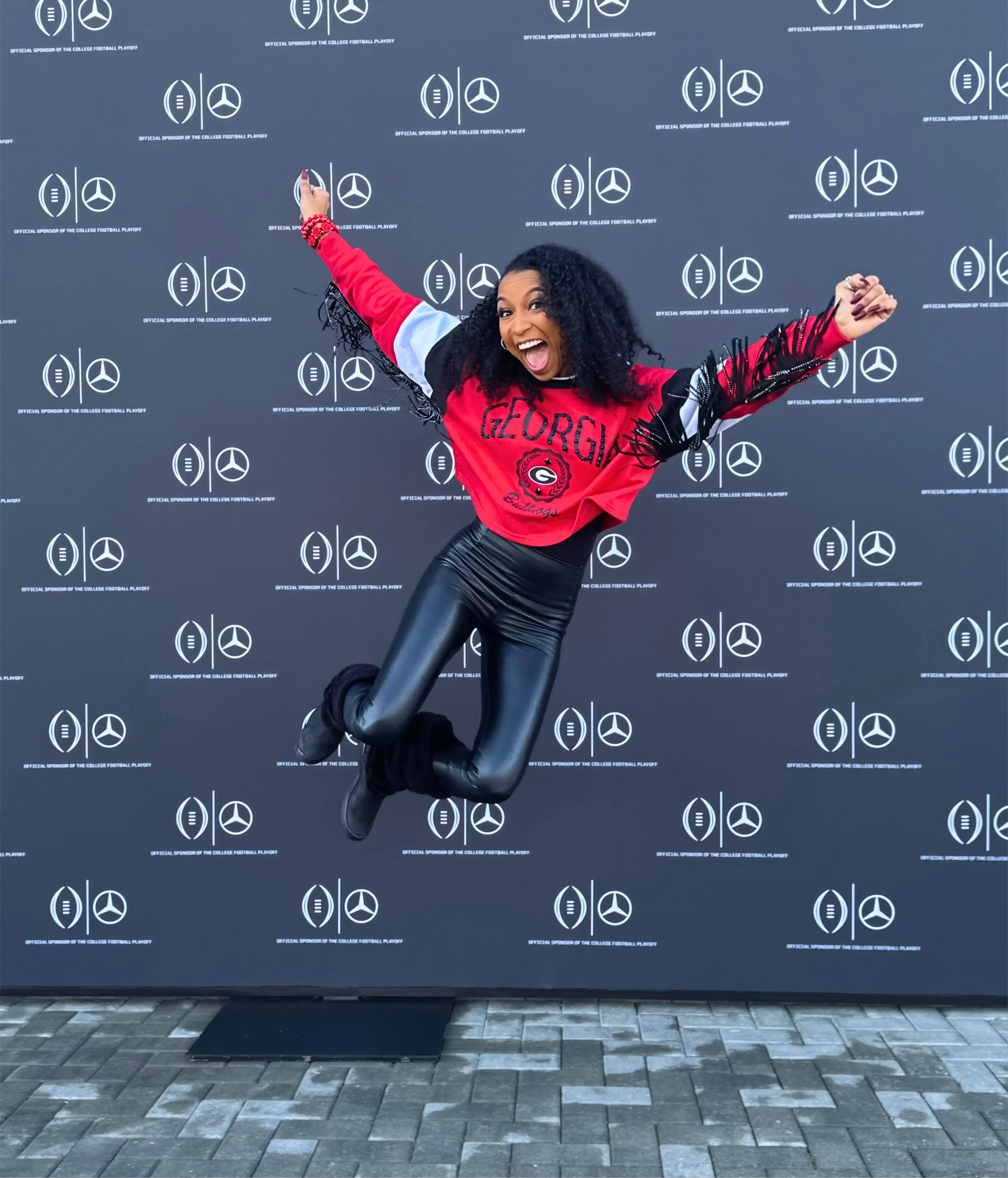 Chelsea jumping for joy while hosting for the UGA watch party at Mercedes Benz Athens.