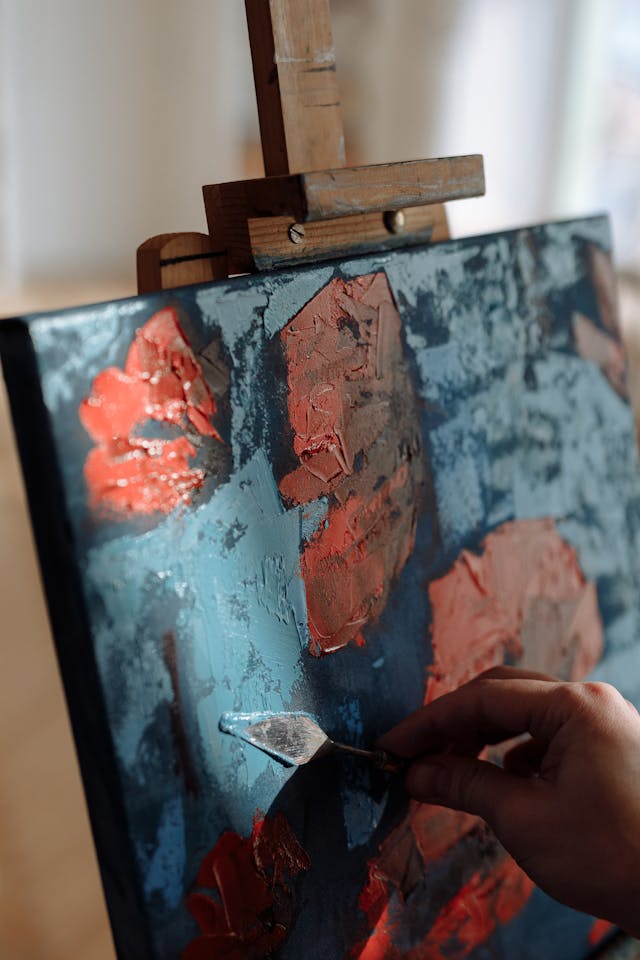 Image of an oil painting with red flowers.
