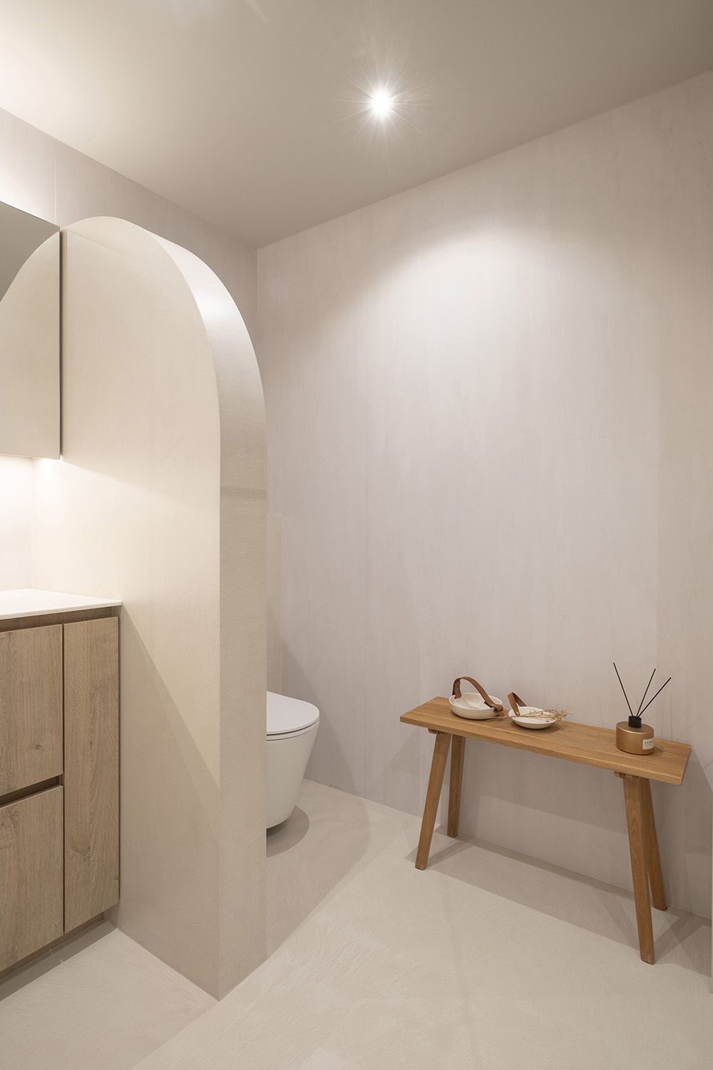 Badkamer met wc en een muur van afgeronde hoeken