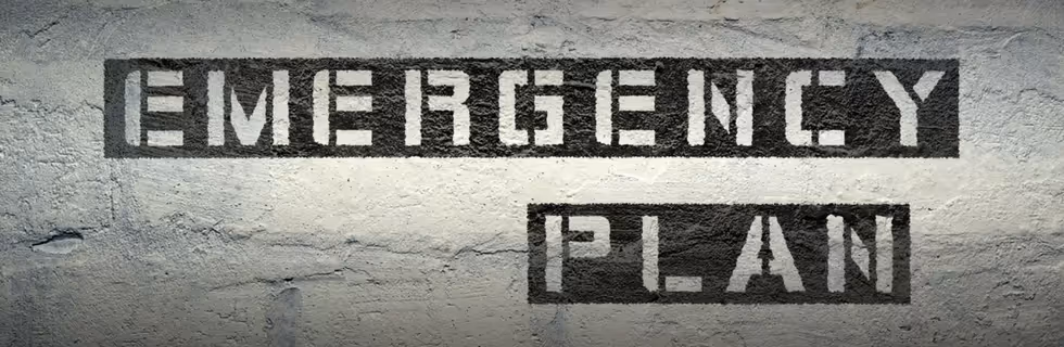 Emergency plan text stenciled on concrete wall with textured background