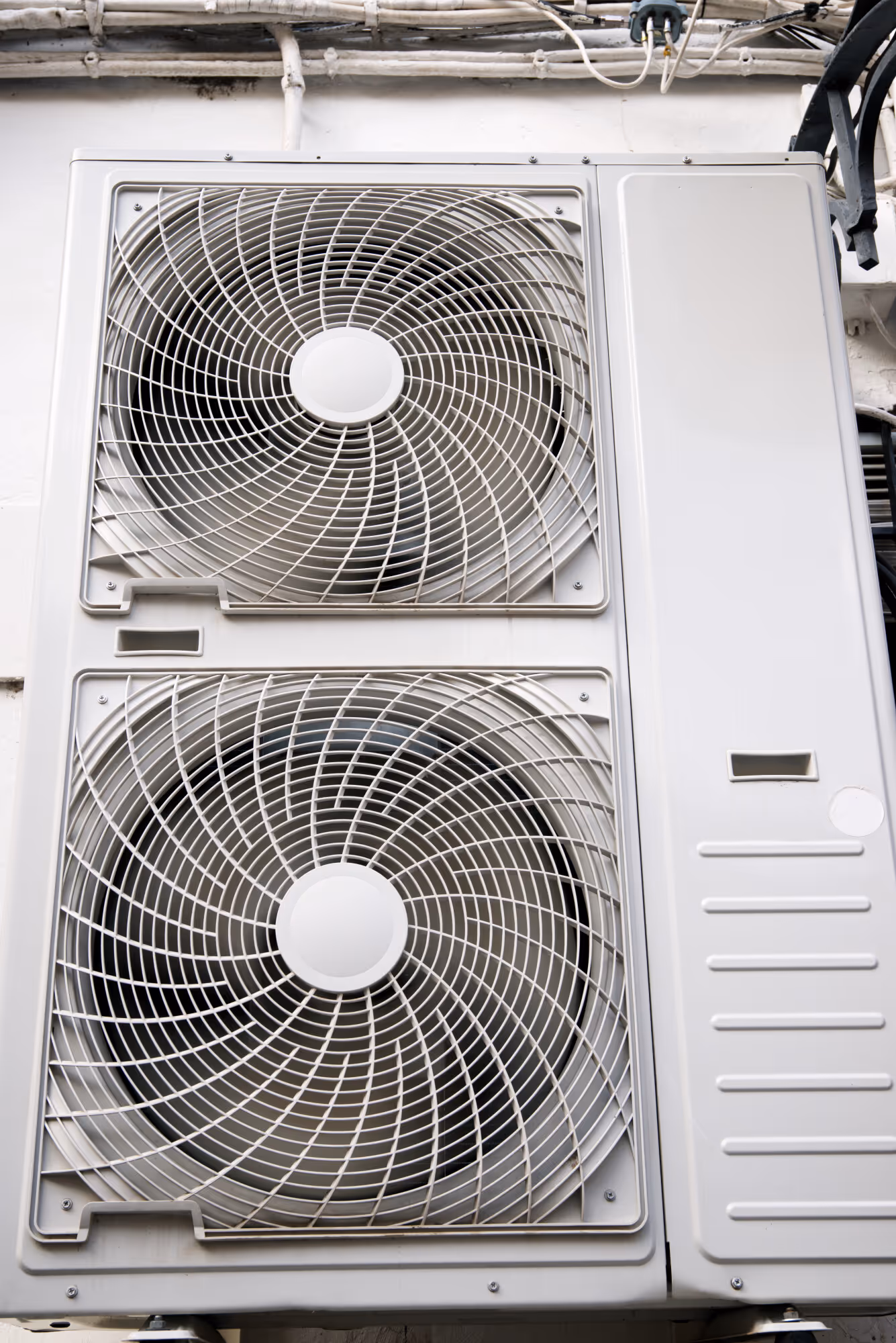 Two large white air conditioning unit fans mounted on exterior wall