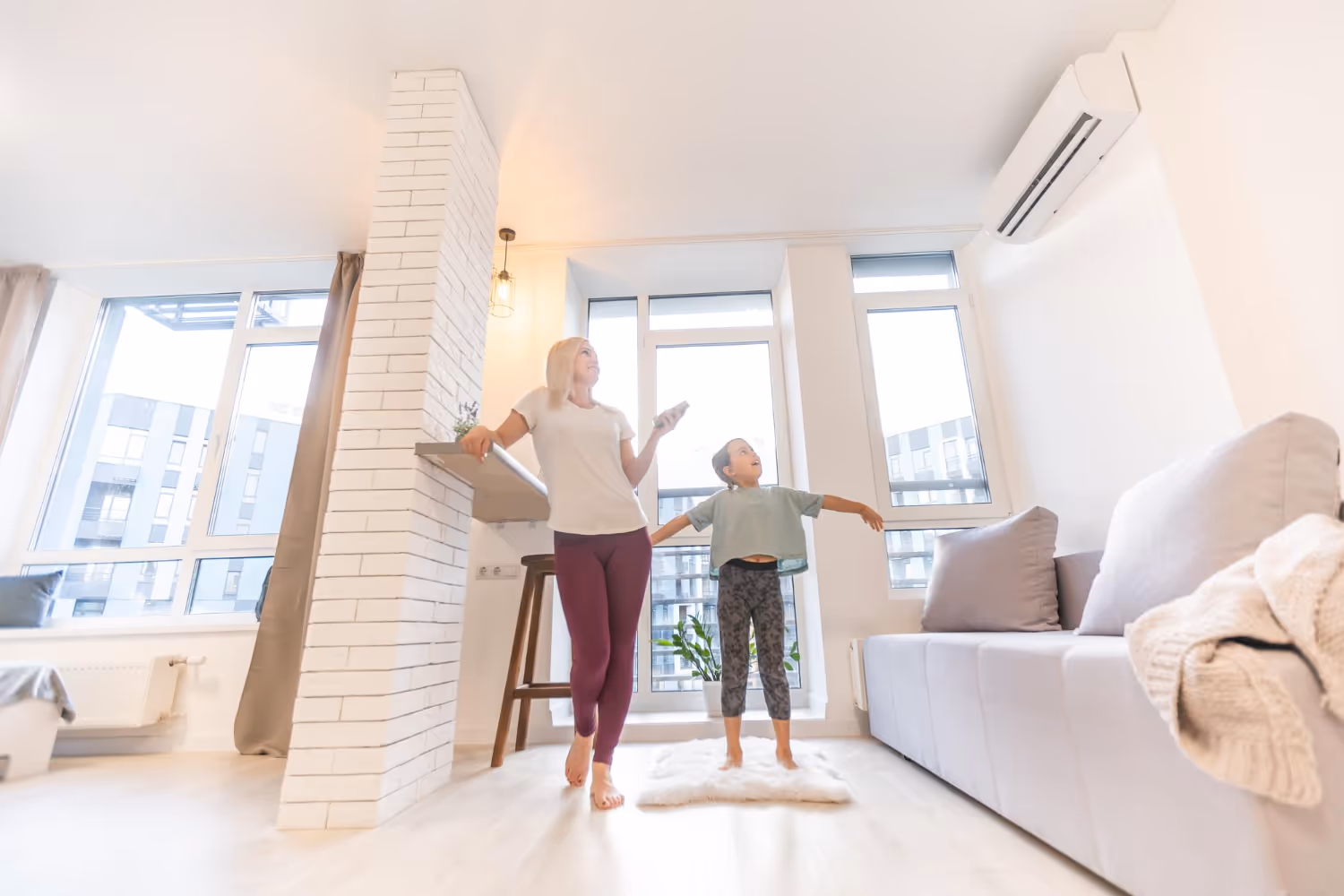 Parent and child doing stretching exercise together in bright living room