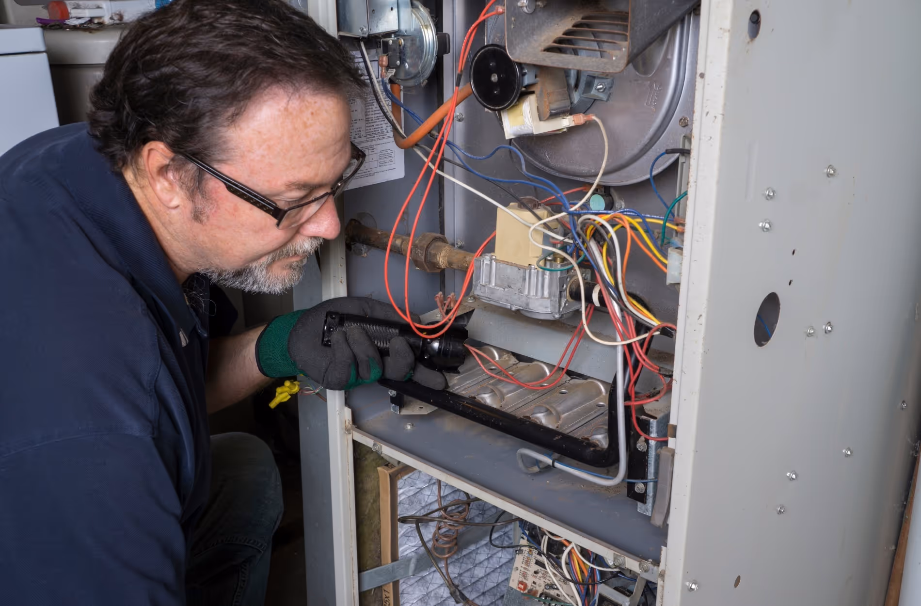 Technician repairs electrical wiring inside an industrial equipment panel