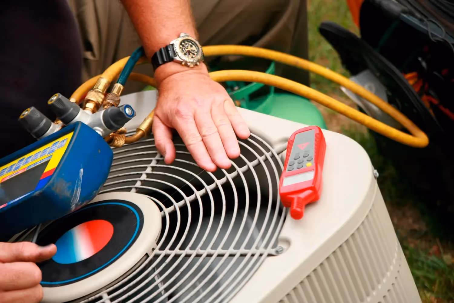 Technician checking air conditioning unit with tools and digital gauge