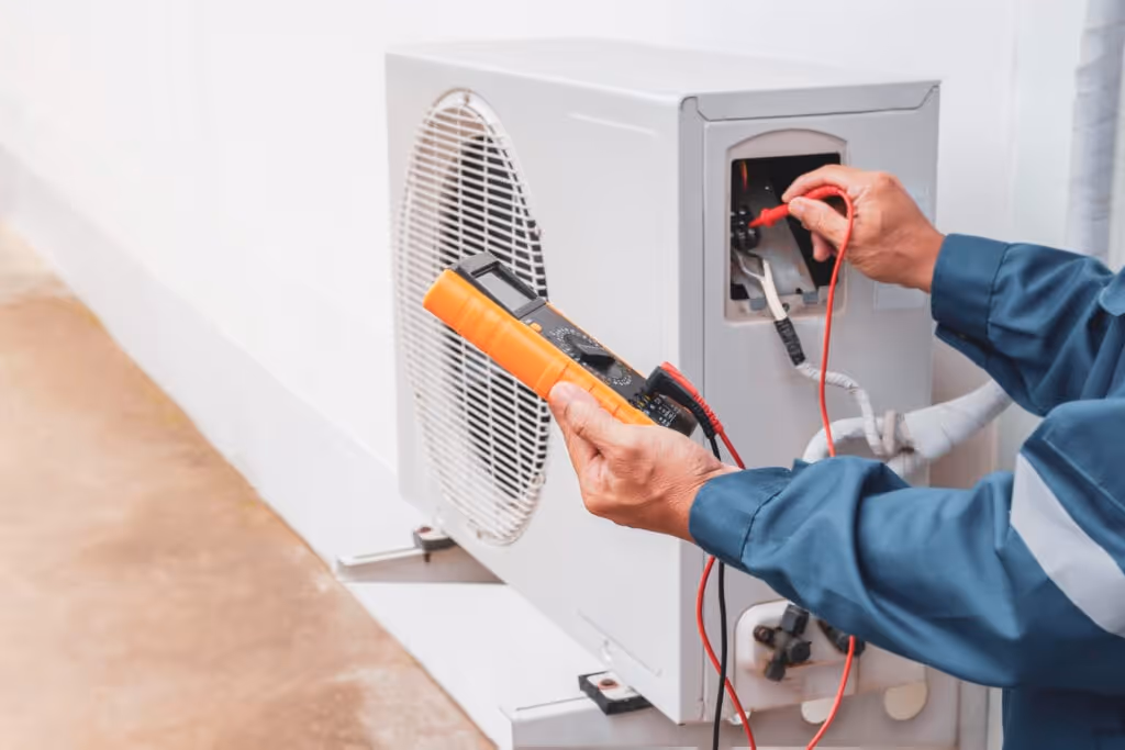 Technician using multimeter to check electrical connections on air conditioner