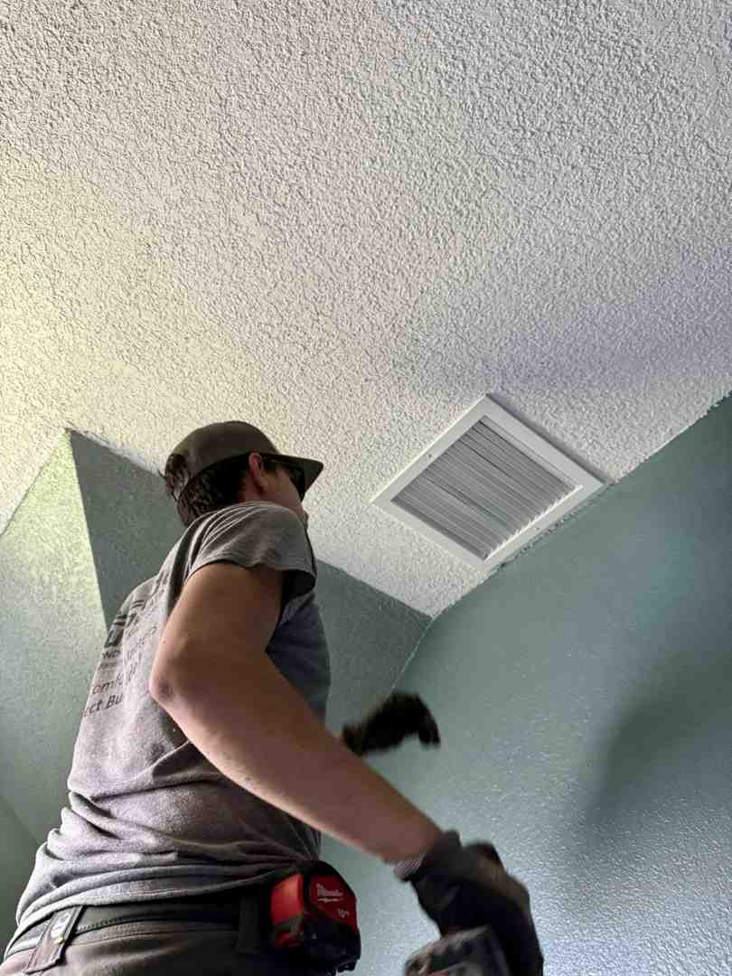homeowner replacing a pleated air filter in a return air vent