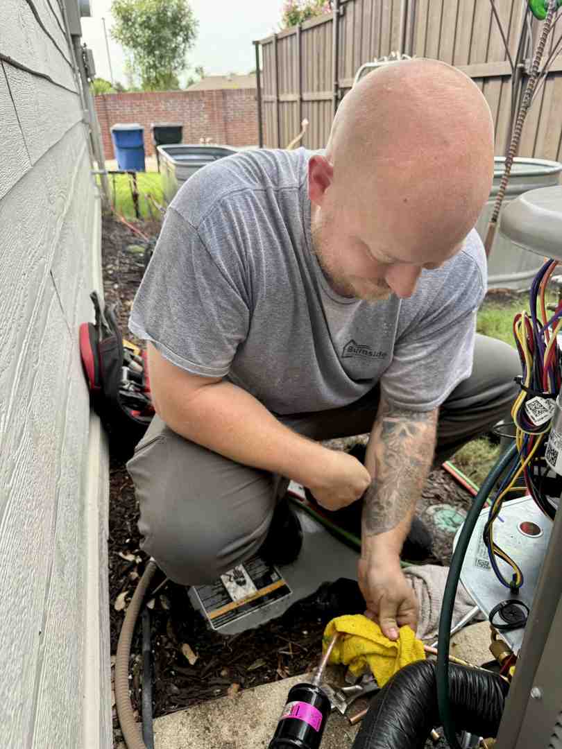 Professional technician cleaning a condenser coil to improve efficiency