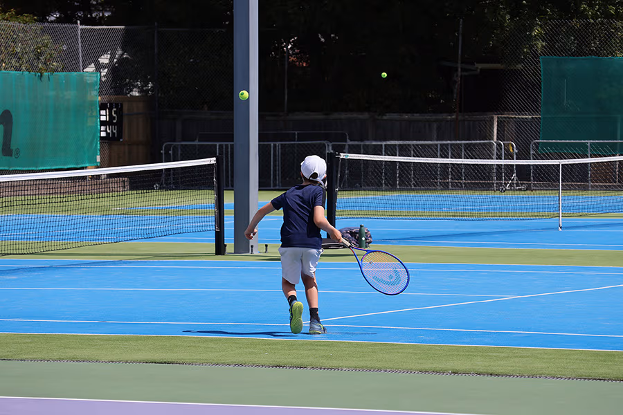 A young boy practicing on the courts at the Waimairi Tennis Club