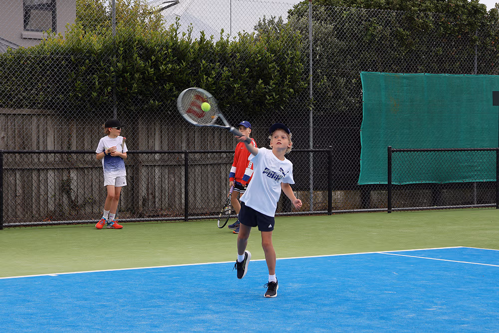 A young player hits a great forehand while practicing on court at the Waimairi Tennis Club