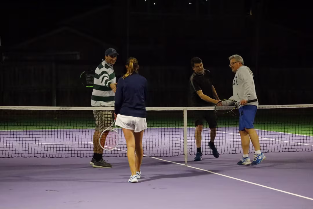 Waimairi Tennis Club Senior Social Night Tennis on the courts - 4 players have just completed a match.