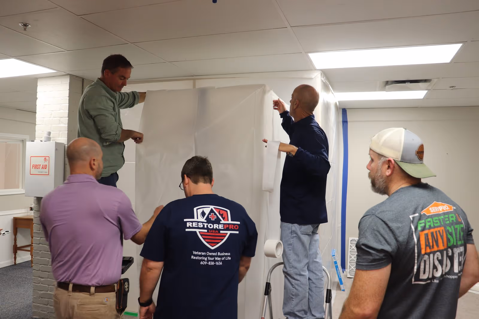 Field training video — AMRT mold remediation training: technicians building a containment chamber at an entrance.