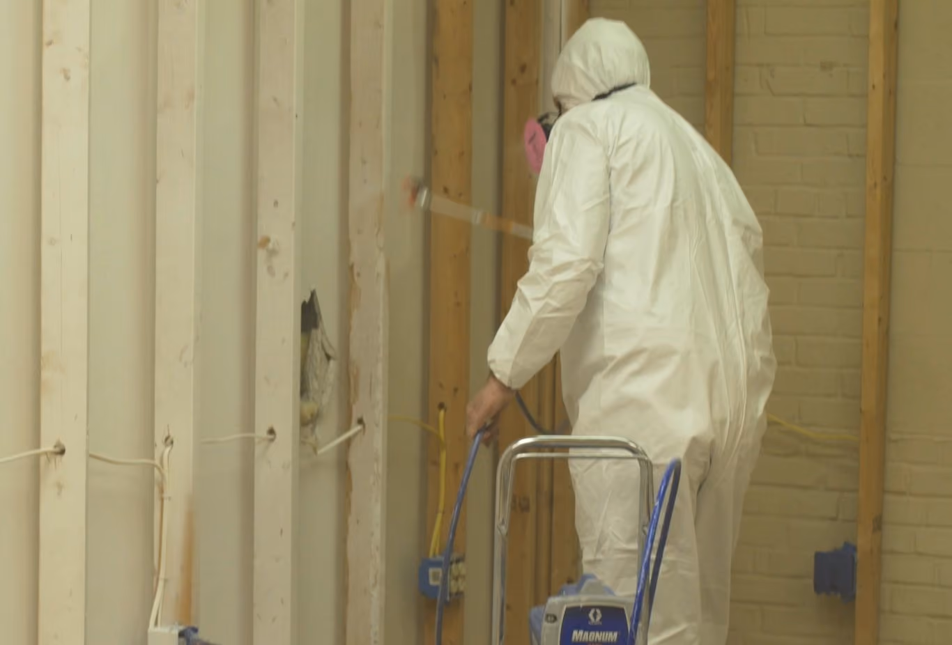 Technician spraying finish onto framing