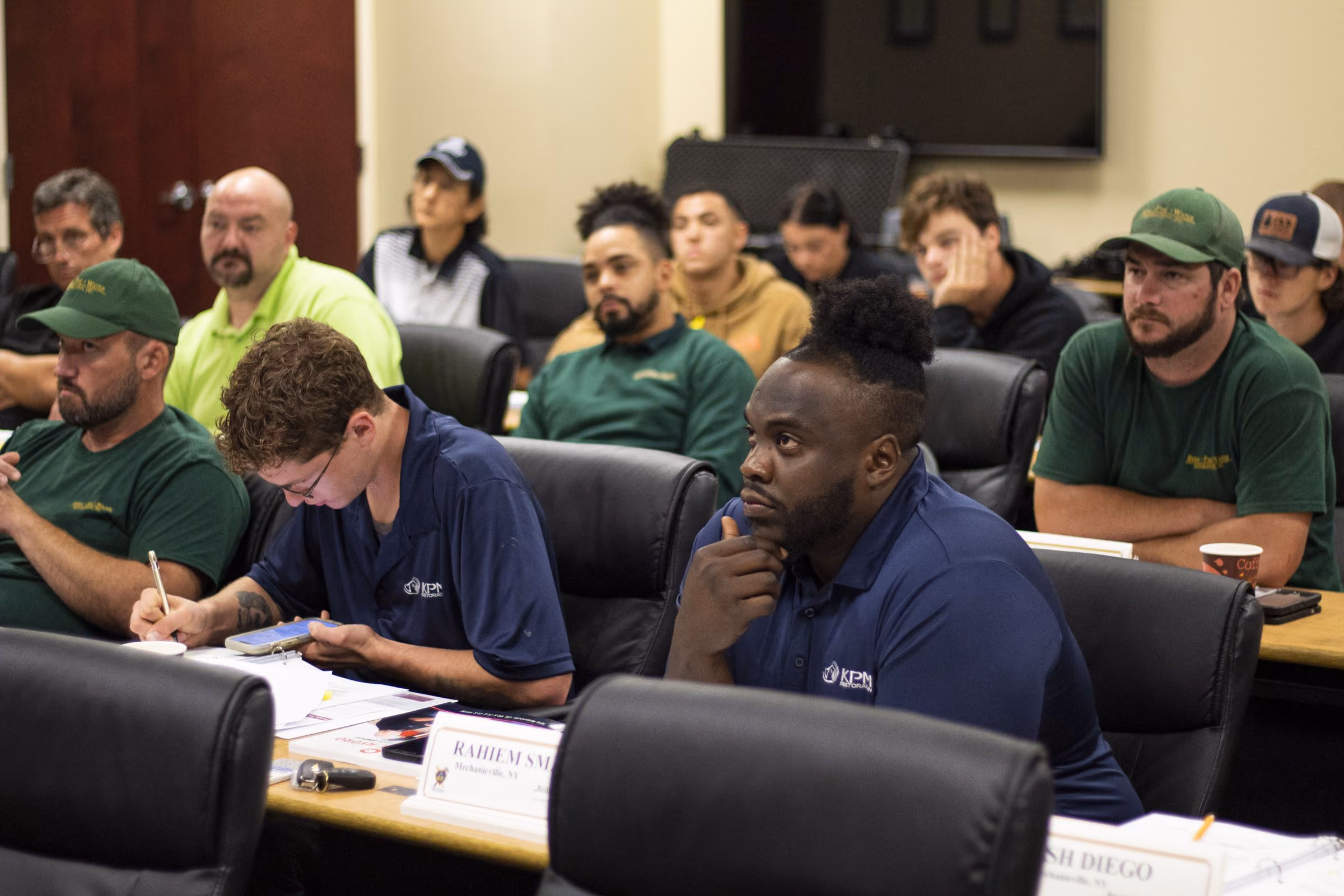 Restoration technicians in a training session taking notes