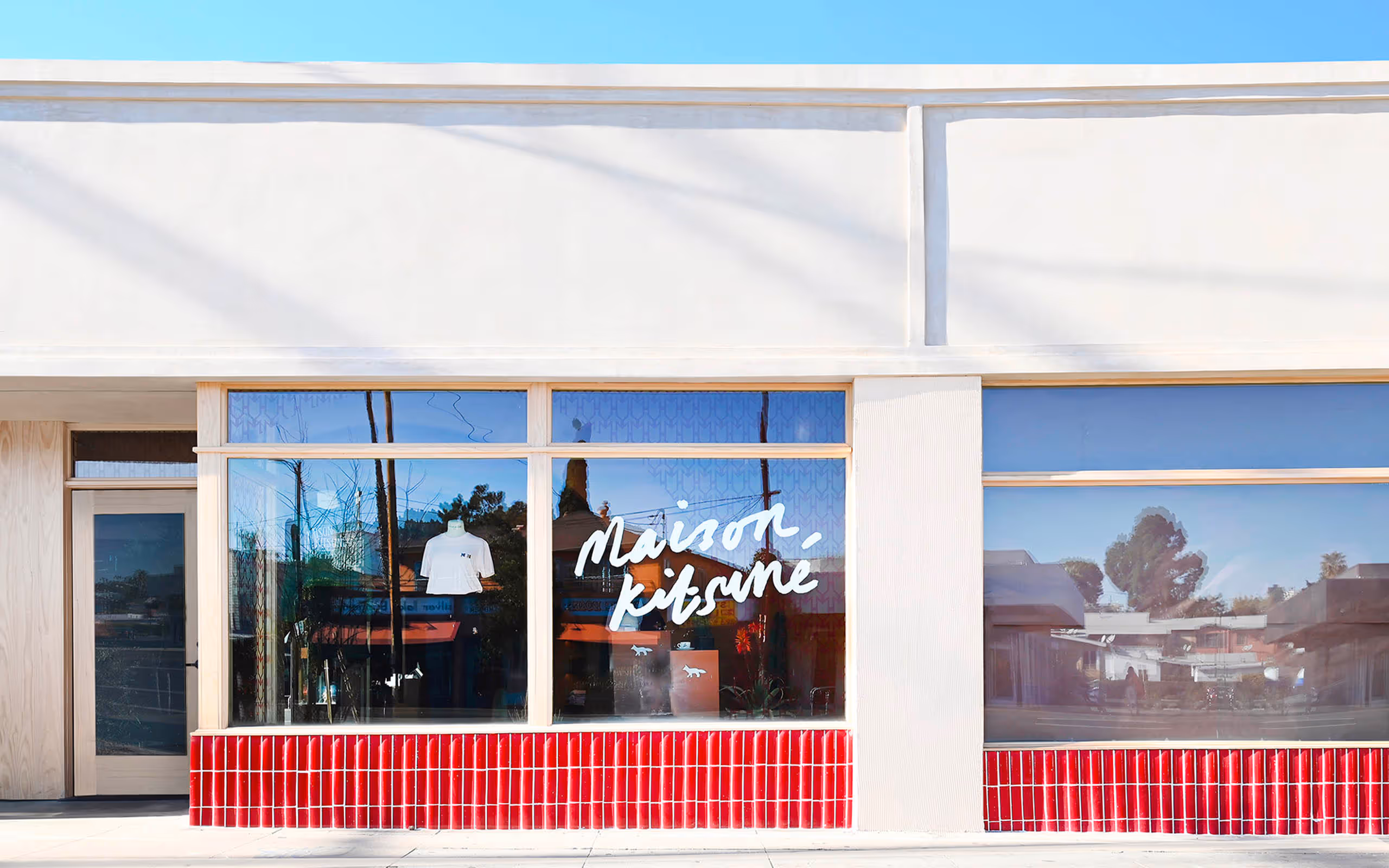 Exterior sidewalk and store front windows of Maison Kitsune