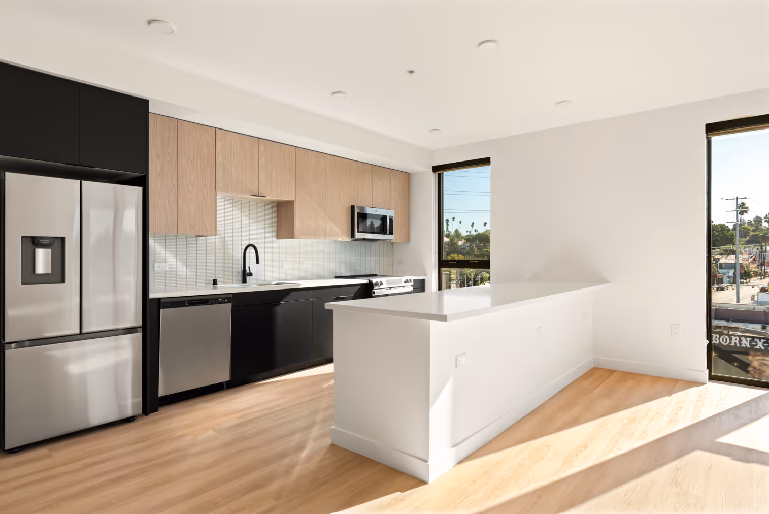 Interior apartment living area showing kitchen and large windows