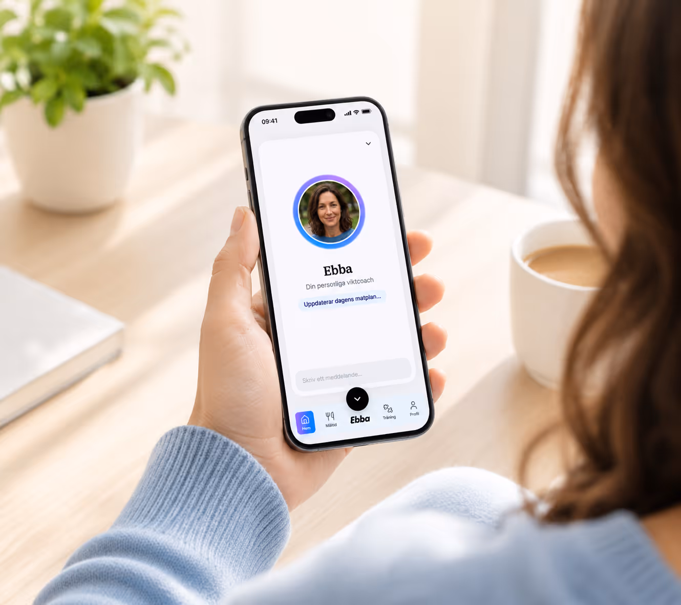 Hand håller iPhone med Ebba-appen öppen som visar din personliga hälsocoach