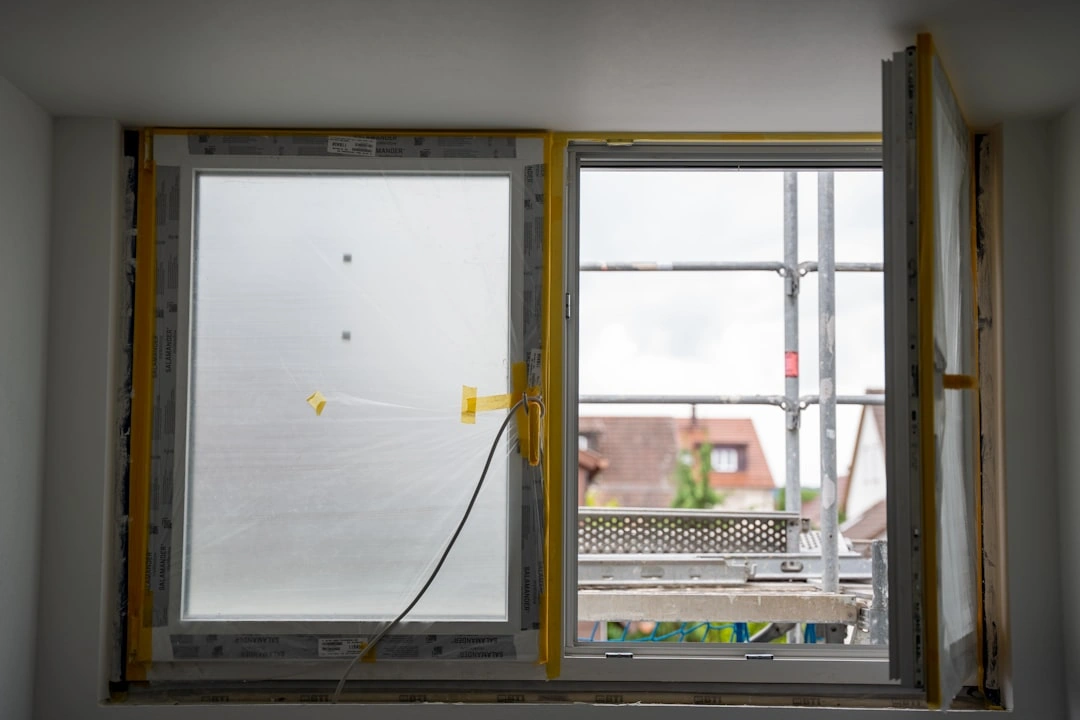 modern replacement window being installed in an older home frame
