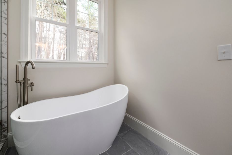 Floor-mounted tub filler installation next to a freestanding pedestal tub Floor-mounted tub filler installation next to a freestanding pedestal tub