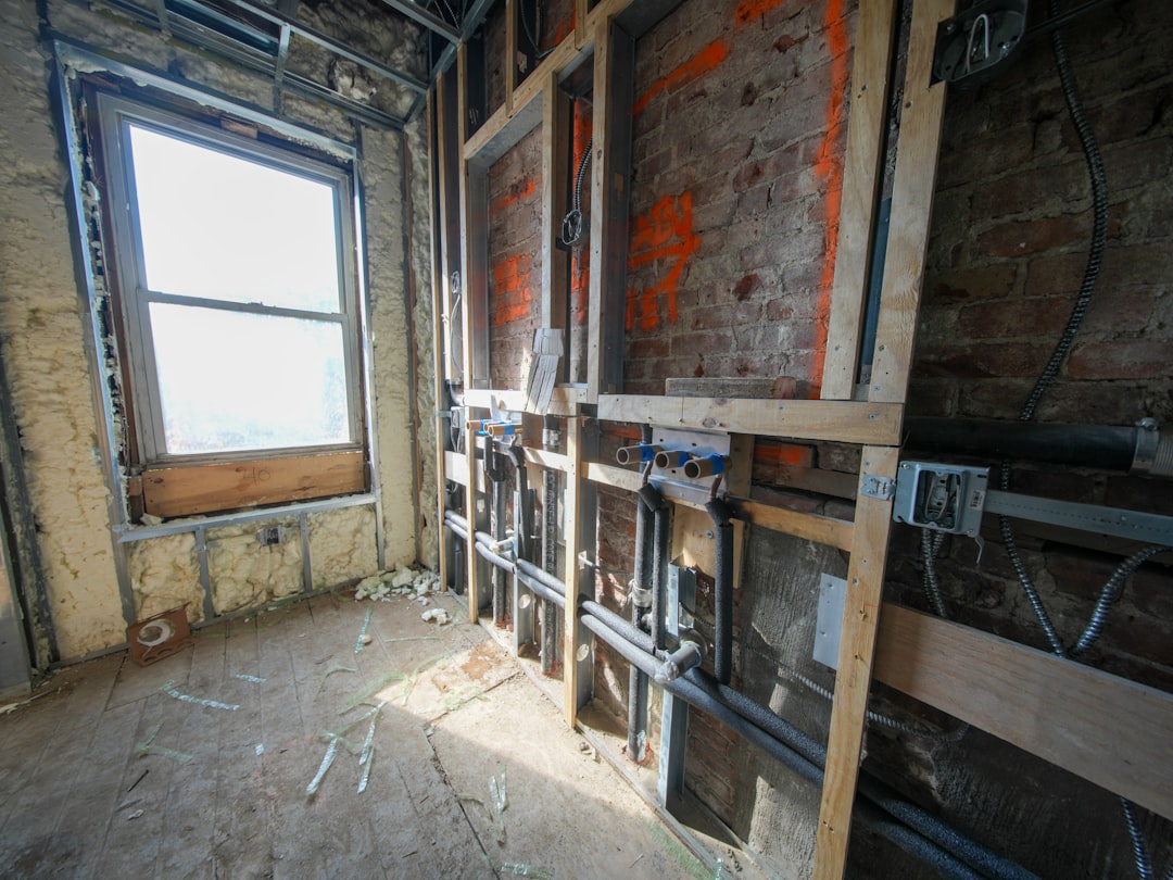 Bathroom during the demolition phase showing exposed studs and plumbing - complete bathroom remodeling