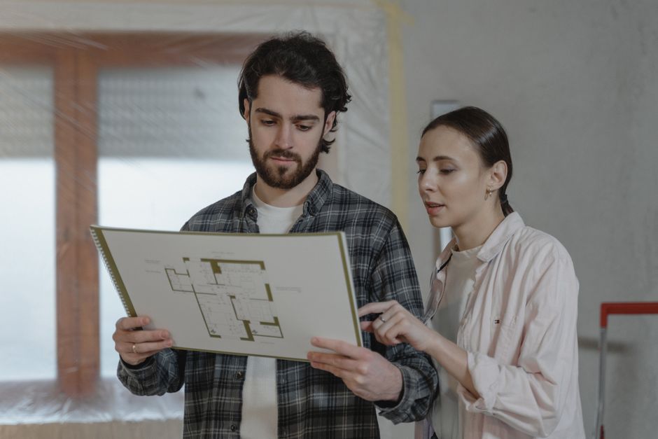 Homeowner and contractor reviewing bathroom blueprints and budget - complete bathroom remodeling