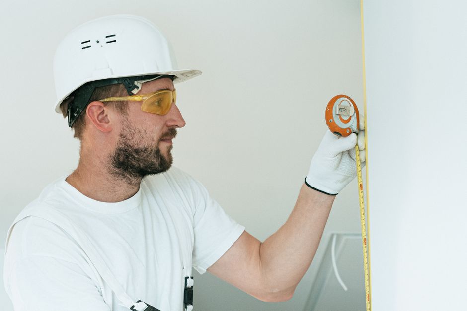 Contractor measuring a bathroom space for a custom renovation - bathroom renovations near me Contractor measuring a bathroom space for a custom renovation - bathroom renovations near me