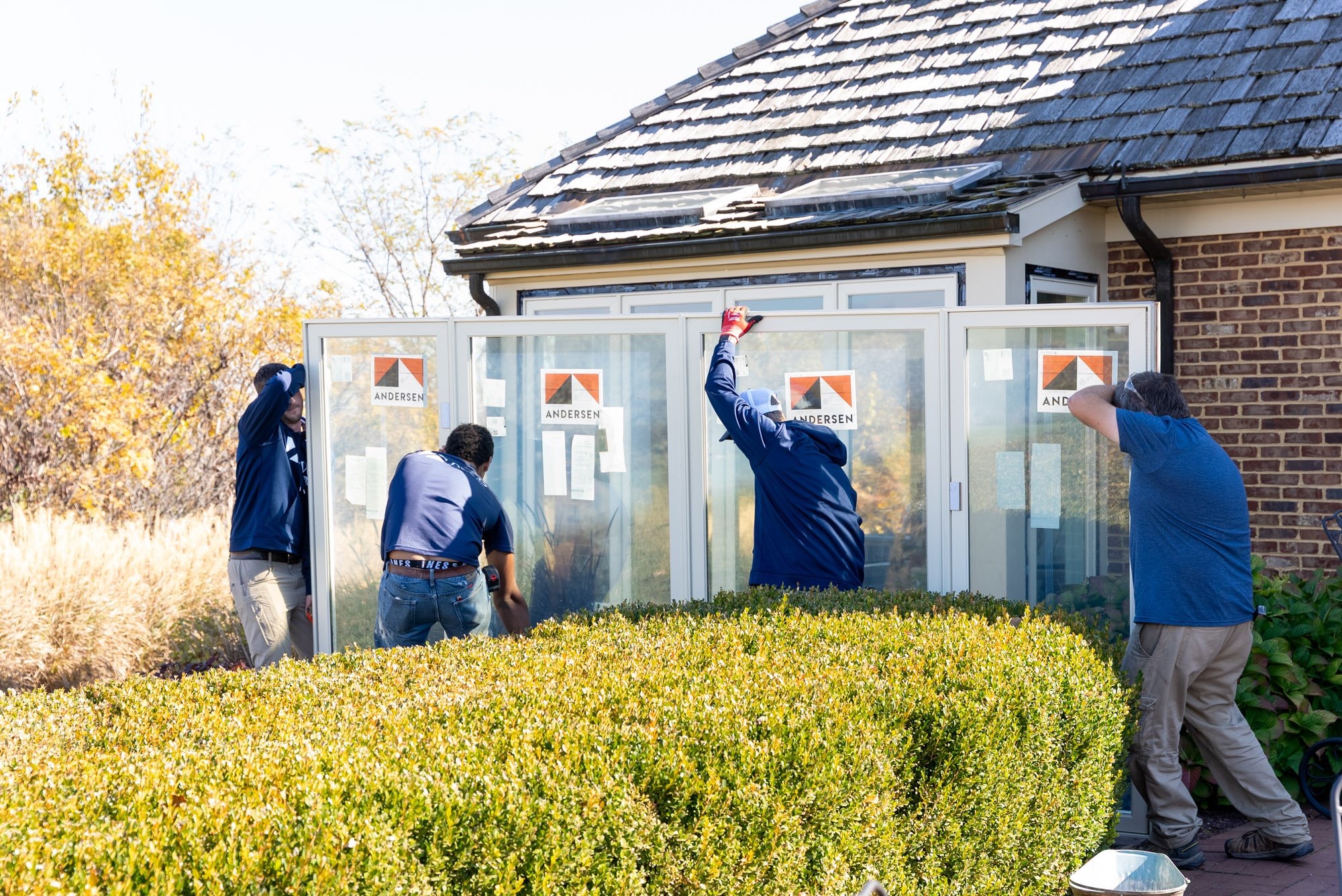 A coordinated crew handles Andersen units during a full replacement project after concealed rot was discovered.
