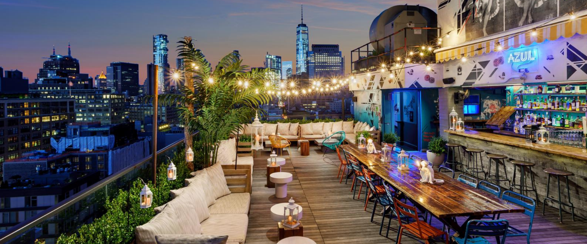 Rooftop bar, city skyline, string lights, communal table at Spring NY in Tribeca
