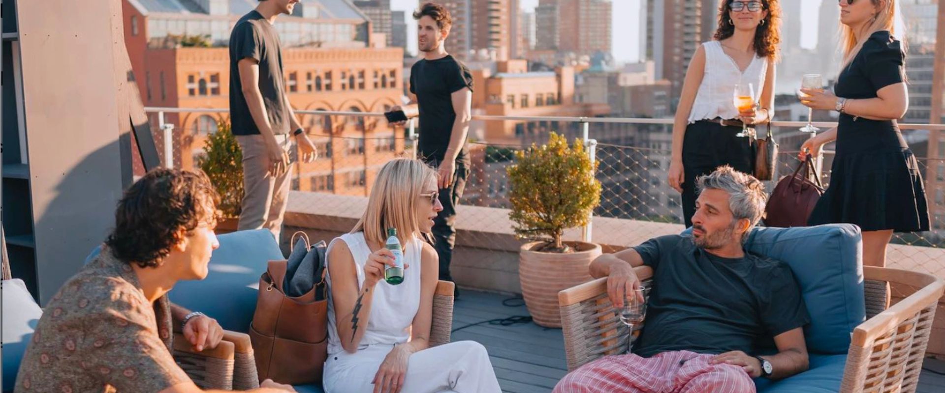 Rooftop bar, city skyline, string lights, communal table at Spring NY in Tribeca