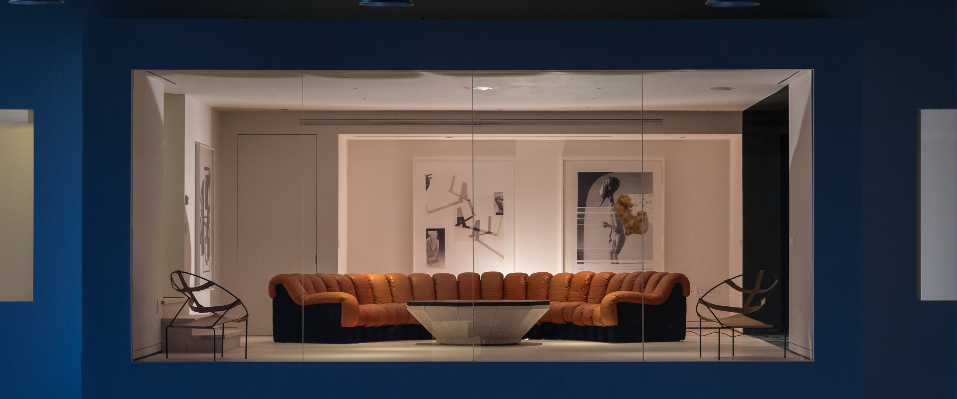 Lounge with modular sofa and glass coffee table inside Spring Studios.