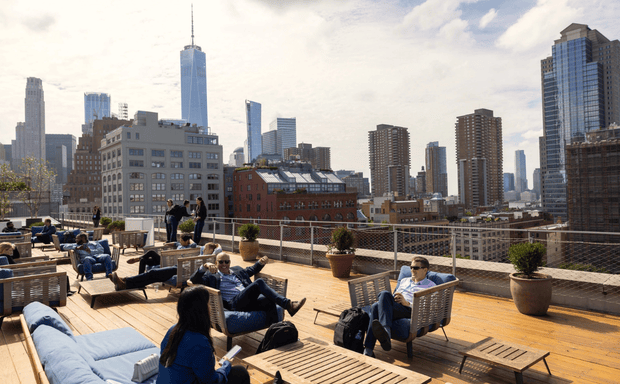 Rooftop lounge with people relaxing and city skyline views