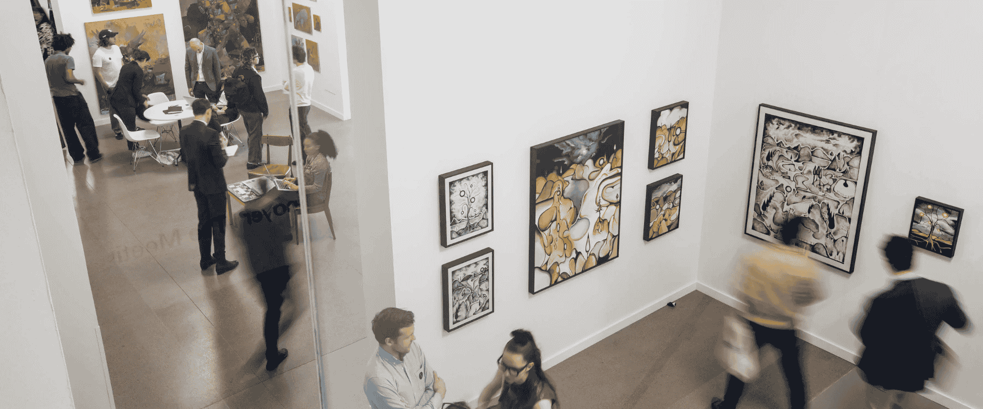 Bright exhibition space with people exploring modern art displays.