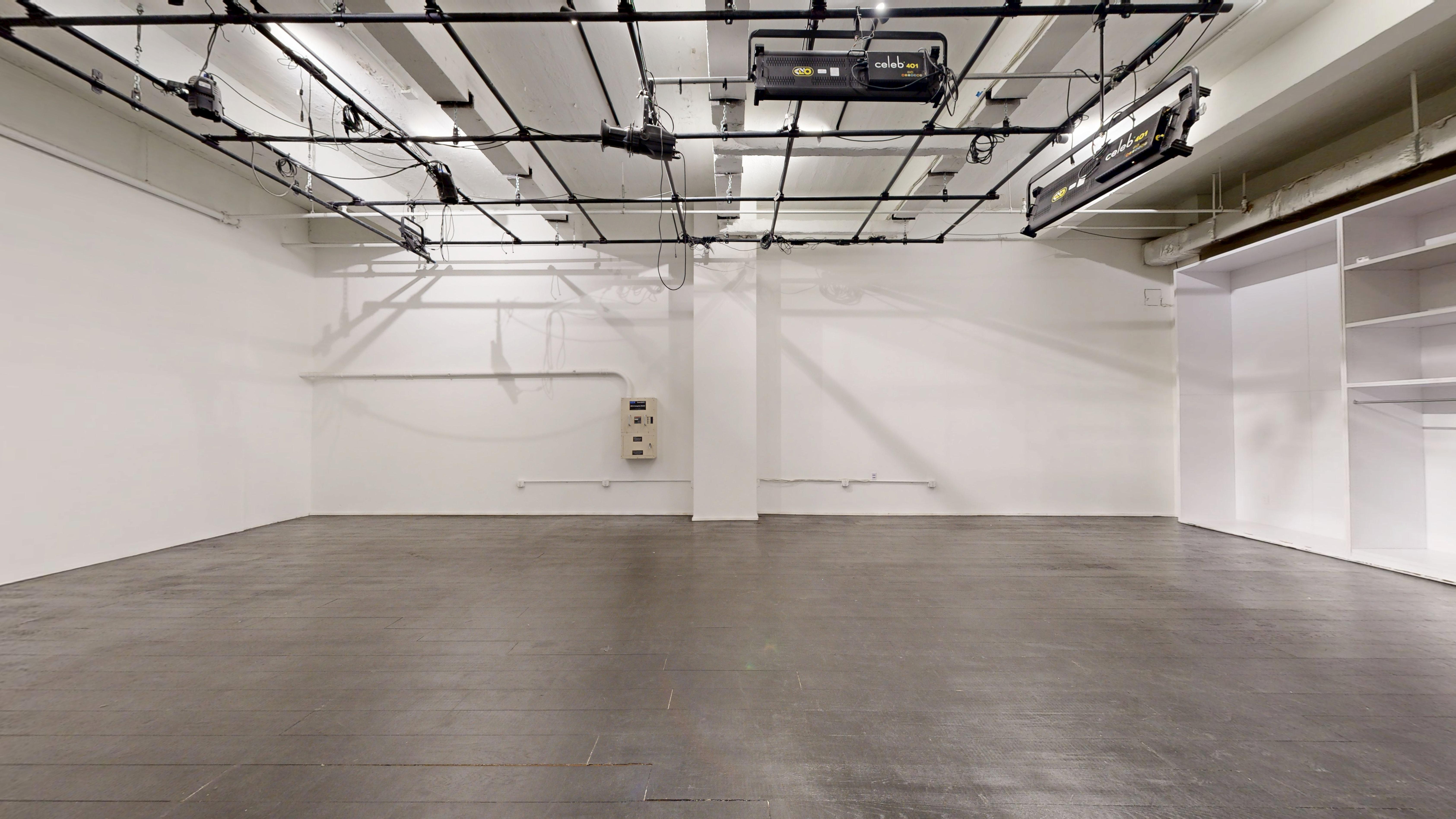 Alternate view of the unfurnished studio showing floor space and minimalist architecture.