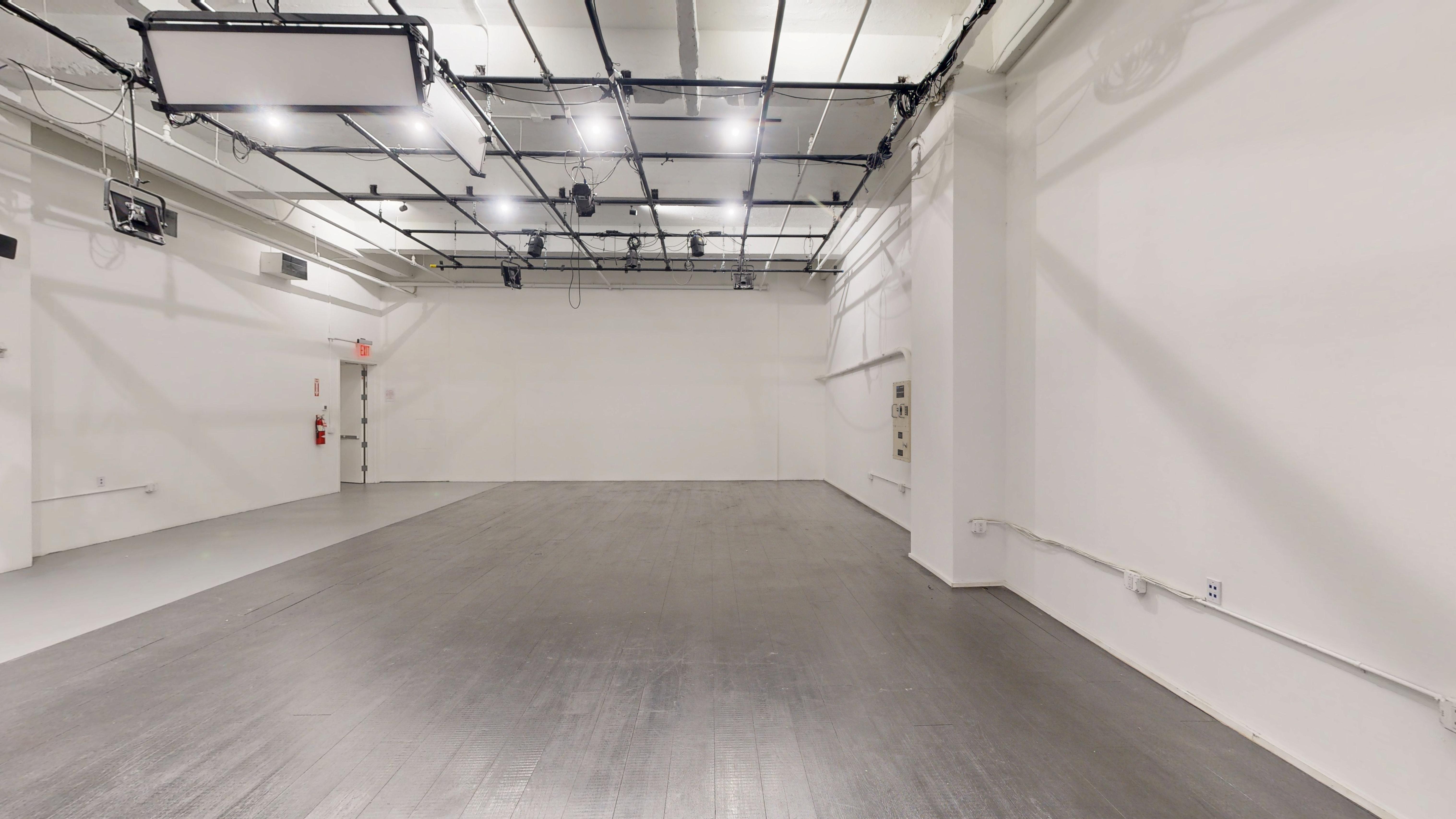 Alternate view of the unfurnished studio showing floor space and minimalist architecture.
