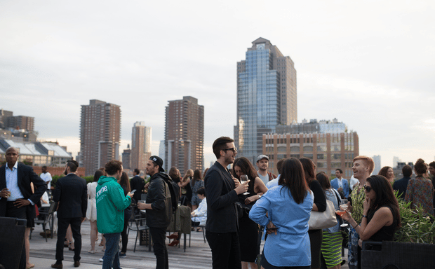 A lively rooftop gathering where a diverse group of people are socializing