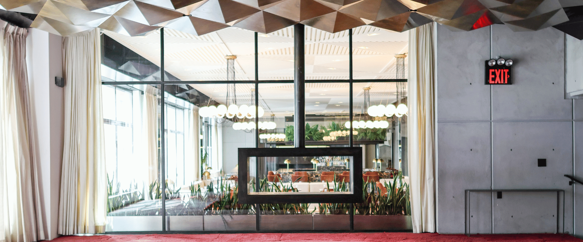 Luxury event space featuring red velvet sofa and geometric ceiling