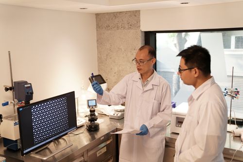 Scientists discussing droplet microfluidics data in a life science laboratory at Blacksheep Sciences.