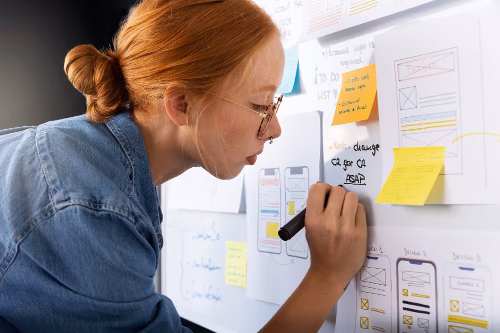 Employée préparant la stratégie de la refonte d'un site sur un tableau
