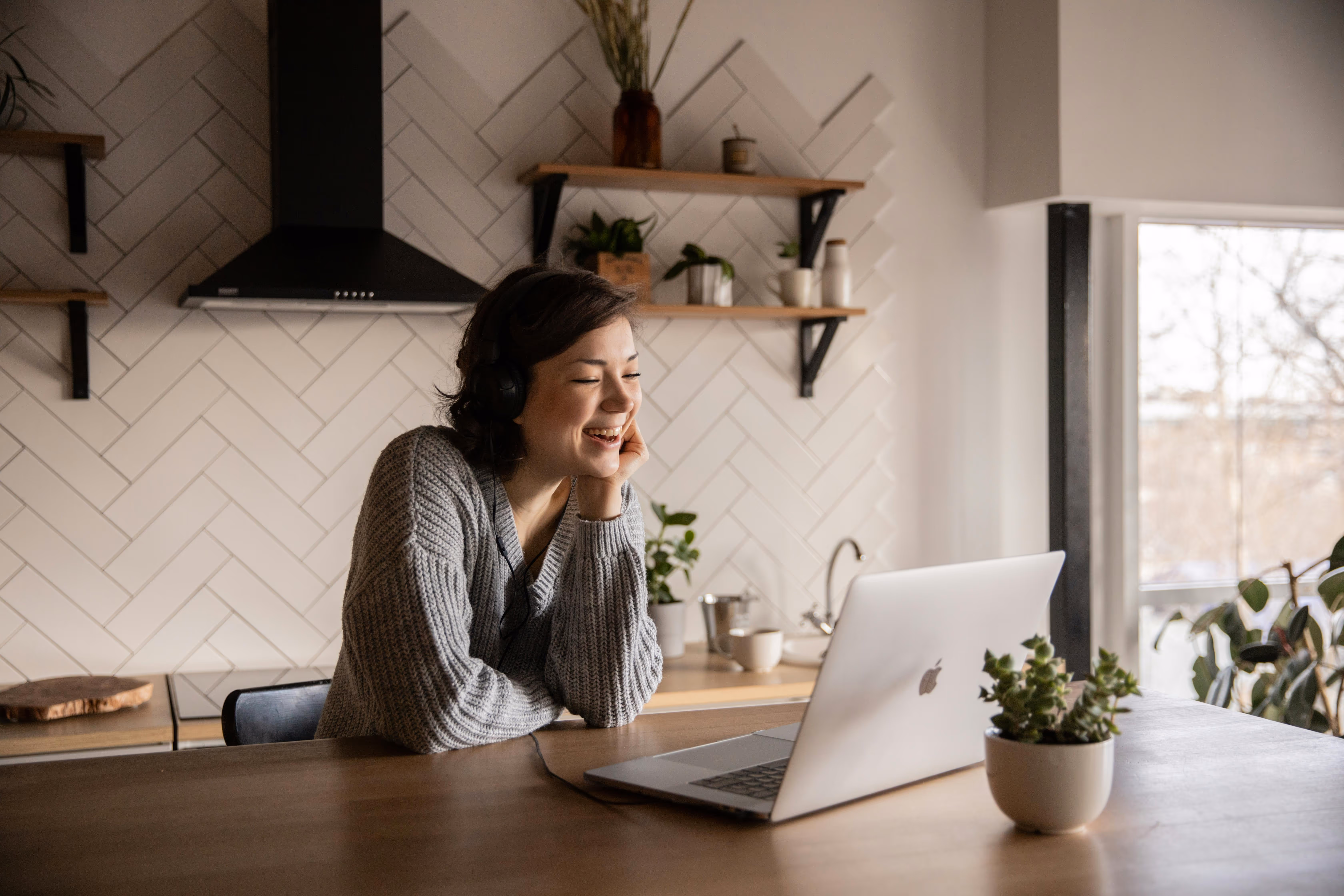 Frau mit Kopfhörern lacht vor Laptop – Individuelles BEM-Fallmanagement von moveUP mit persönlicher Begleitung