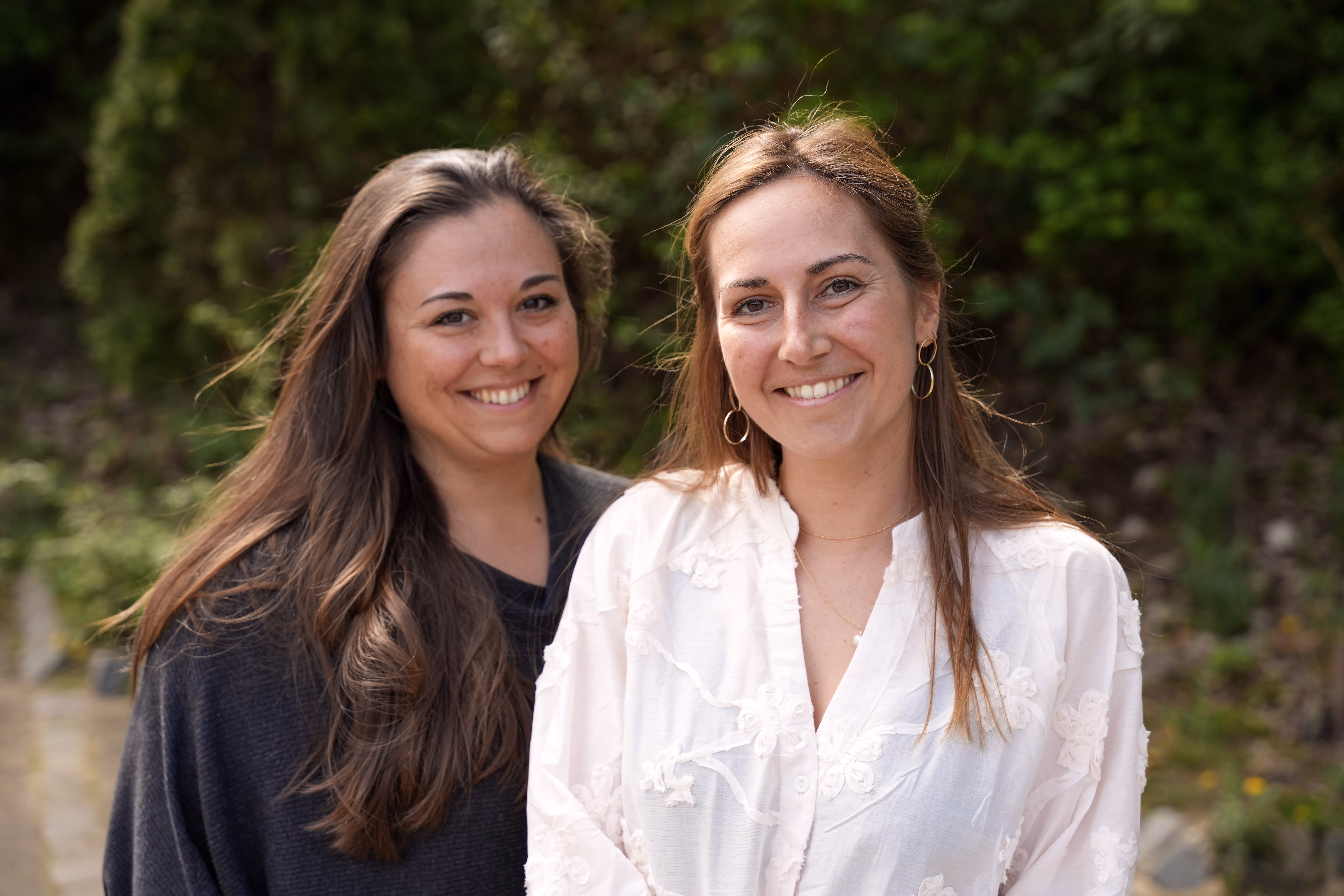 Geschäftsführerinnen Lena Brech und Caroline Thiel sitzen lächelnd auf einer Steintreppe – Vision und USP von moveUP