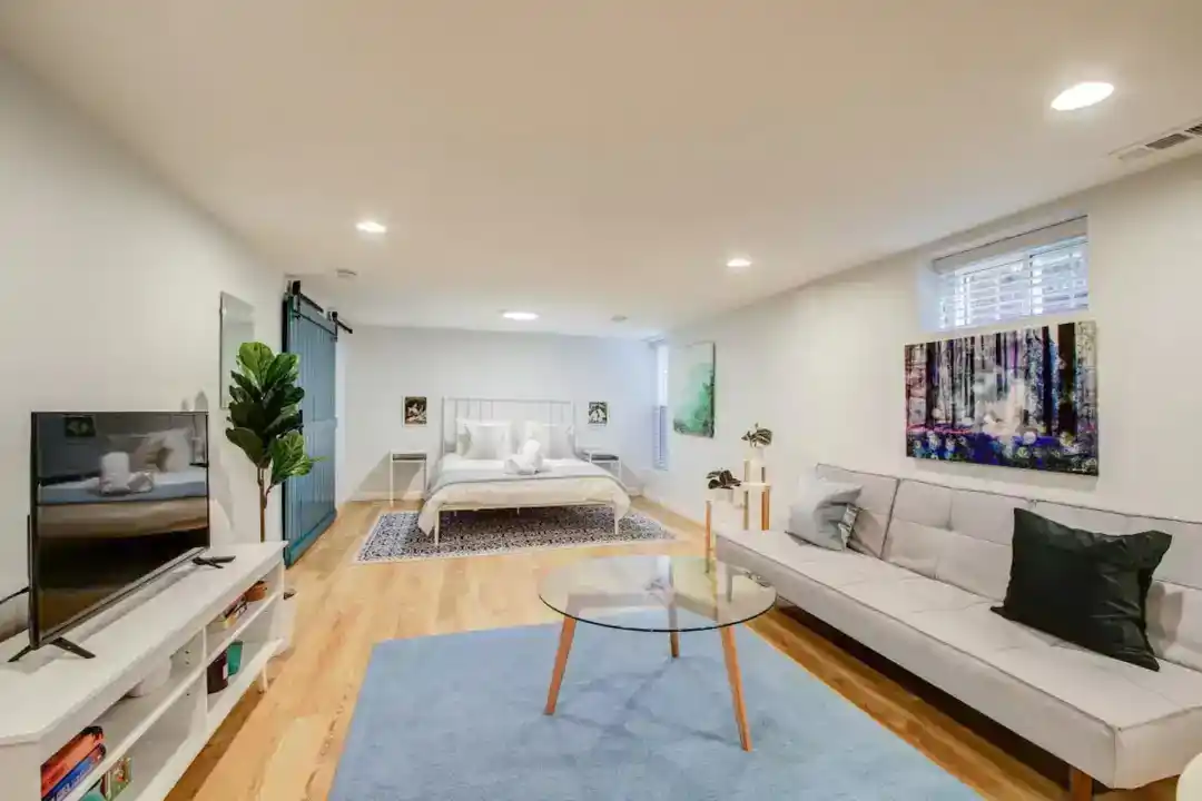 a living room with a large blue rug and a white couch