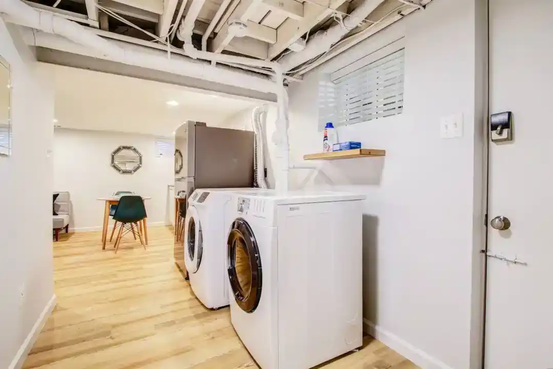 a room with a washing machine and a chair
