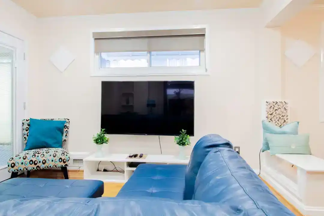 A stylish townhouse accommodation in Washington DC with a bedroom featuring a comfortable bed and a small television