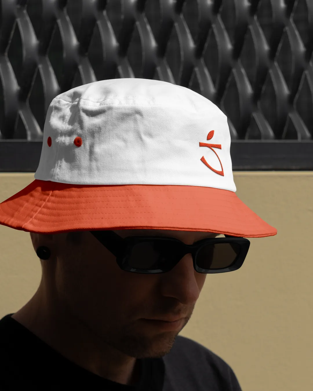 A person wearing a white and red Sapsucker bucket hat embroidered with the brand logo.