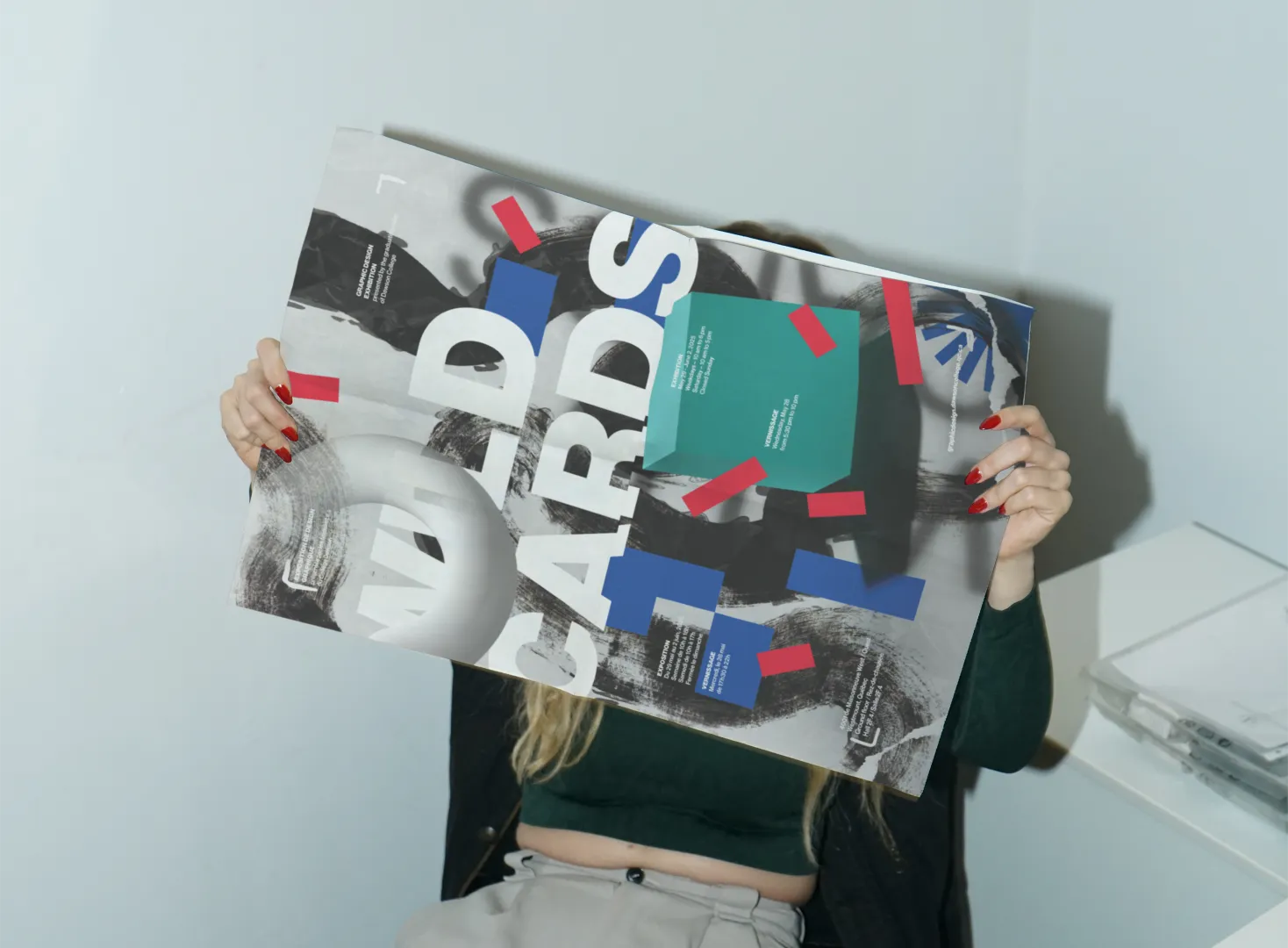 Person seated holding up a Wild Cards poster.