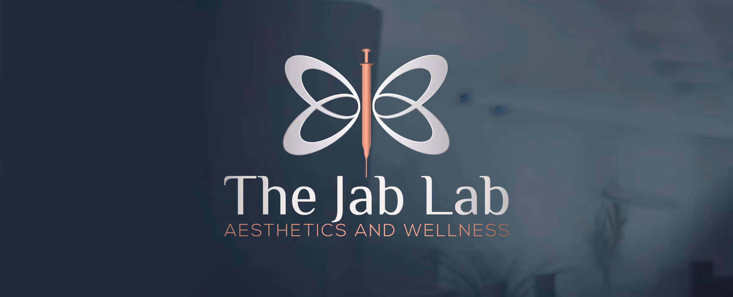 The Jab Lab logo with a butterfly design incorporating a syringe, accompanied by the text 'AESTHETICS AND WELLNESS'.