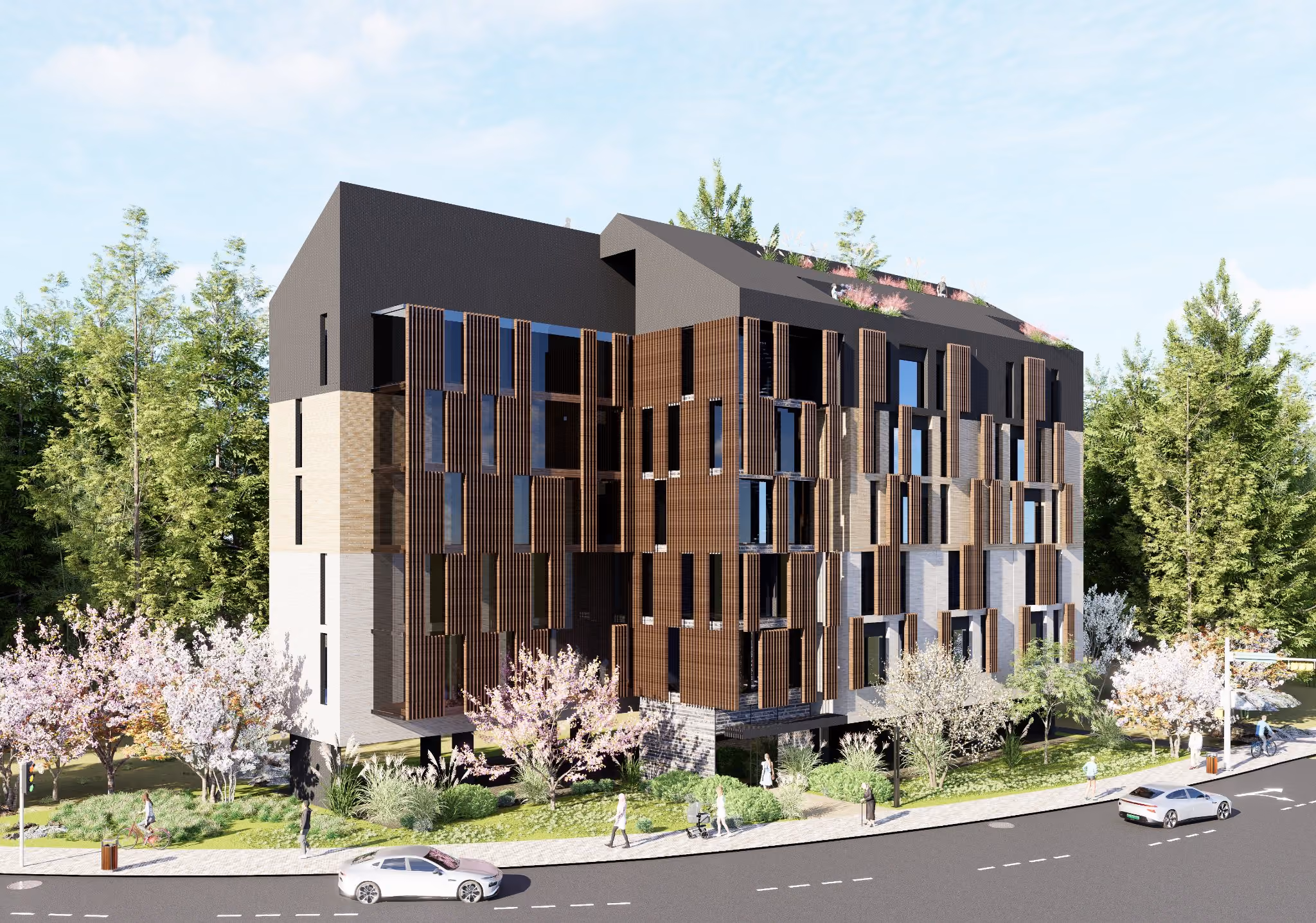 Edificio residencial contemporáneo rodeado de vegetación, con fachada de madera, piedra y amplios ventanales. El diseño incluye celosías verticales de madera que aportan textura y control solar. En la acera, varias personas caminan entre árboles en flor y zonas ajardinadas, mientras algunos coches circulan por la carretera frontal.