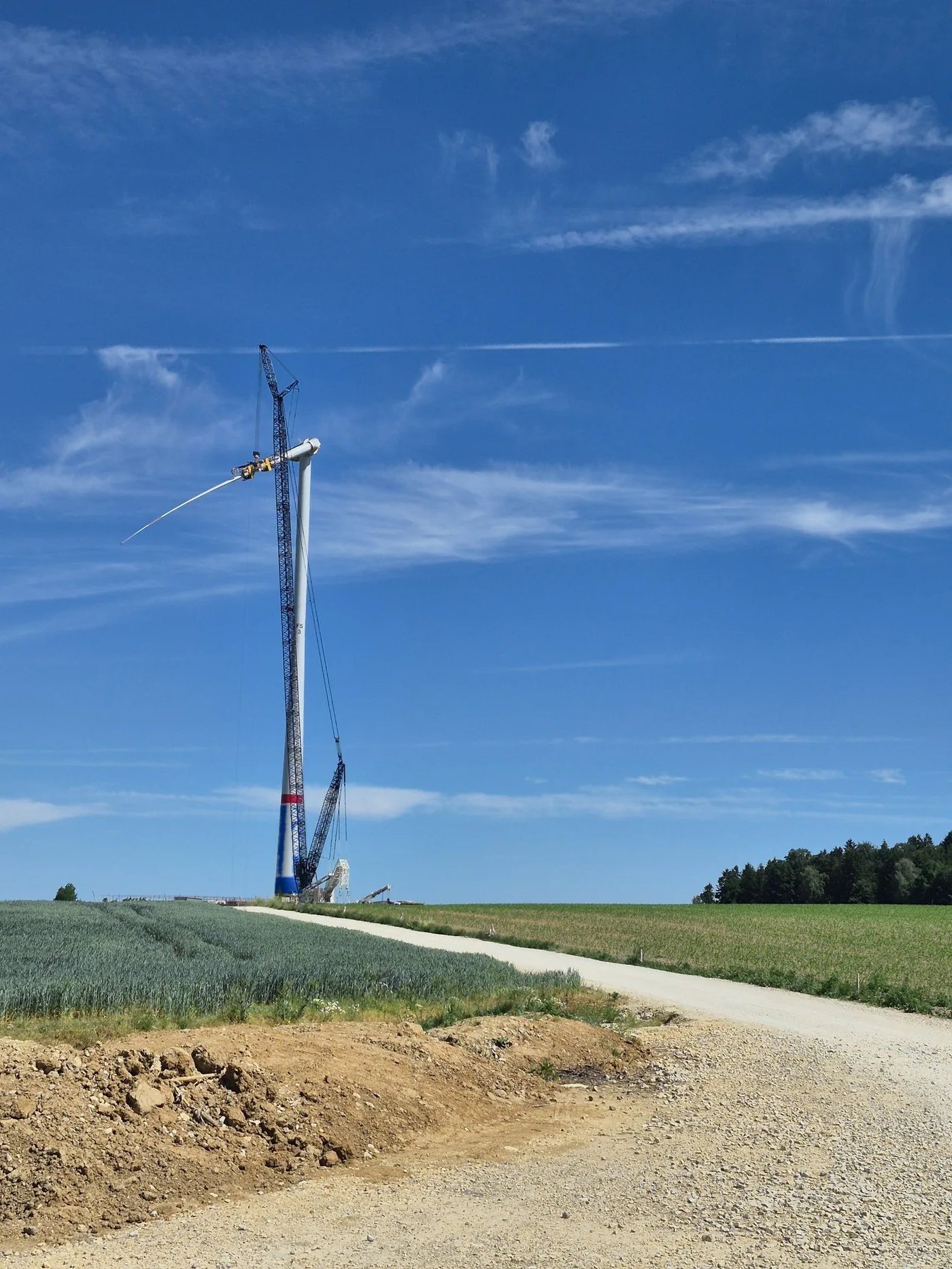 Windenergie-Baustelle: Raupenkran bei der Rotorblatt-Montage, Turmfuß im SAFETEE-Blau